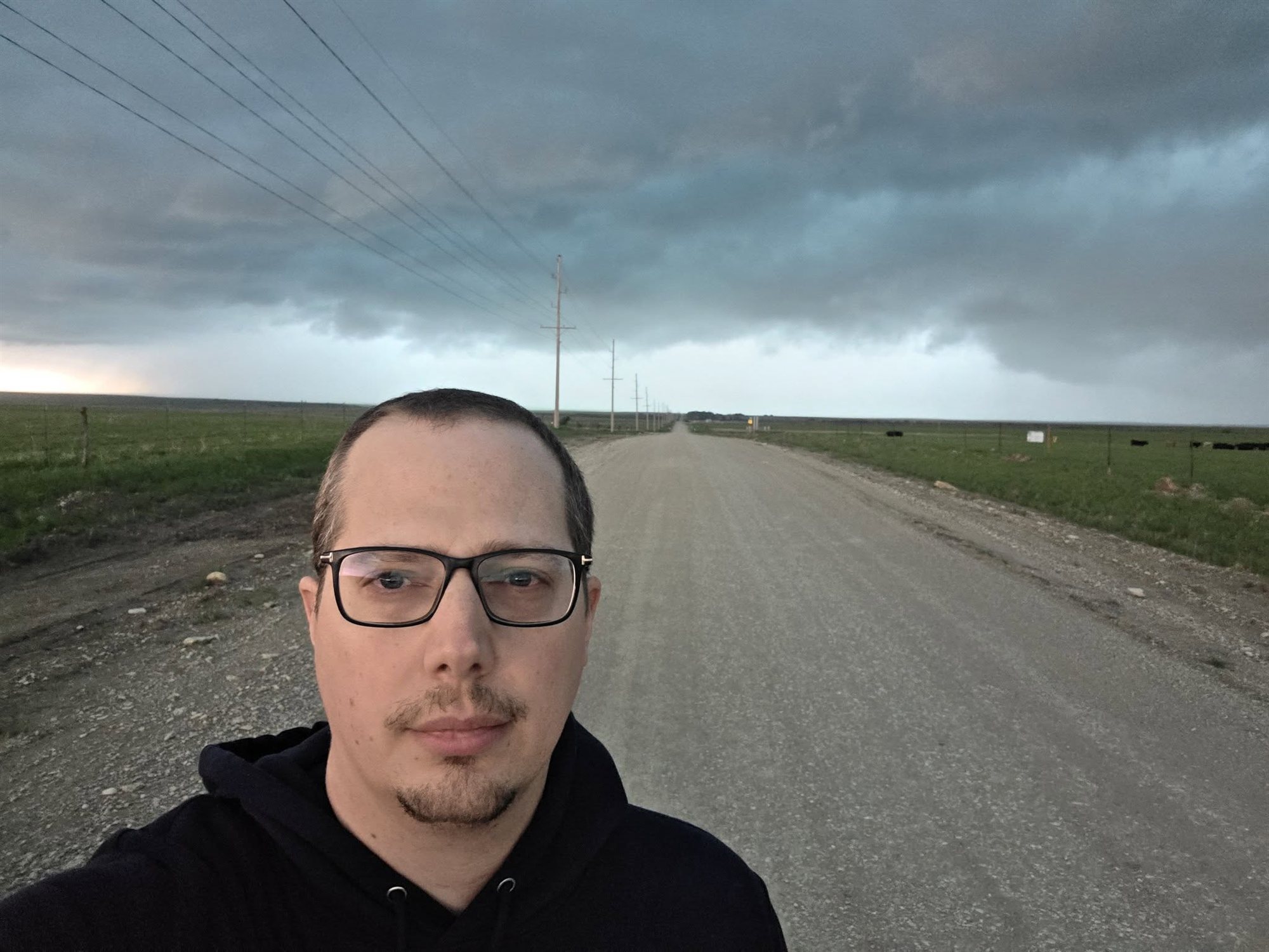 Daan op een onverharde weg op de Great Plains onder een donkere onweershemel in Tornado Alley